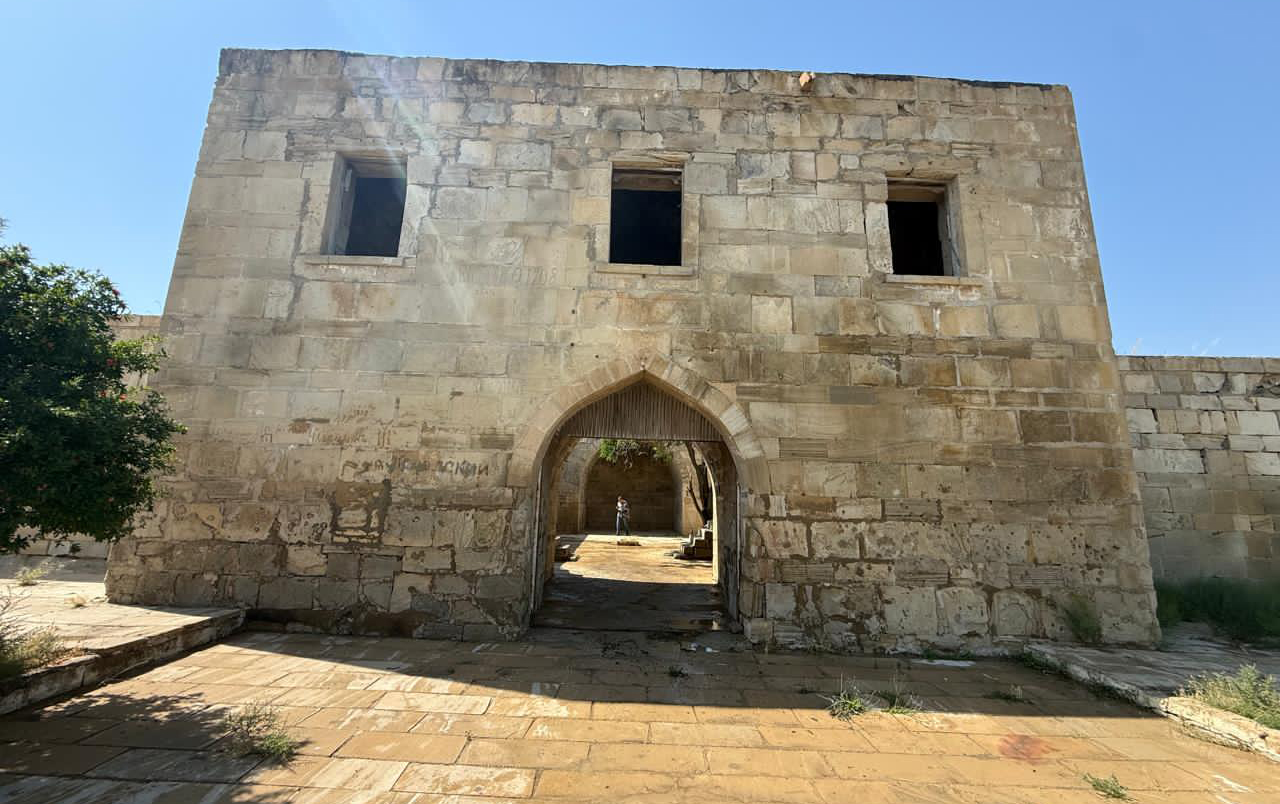 tarixi-karvansaranin-uzerindeki-yazilari-qum-sementle-ortubler